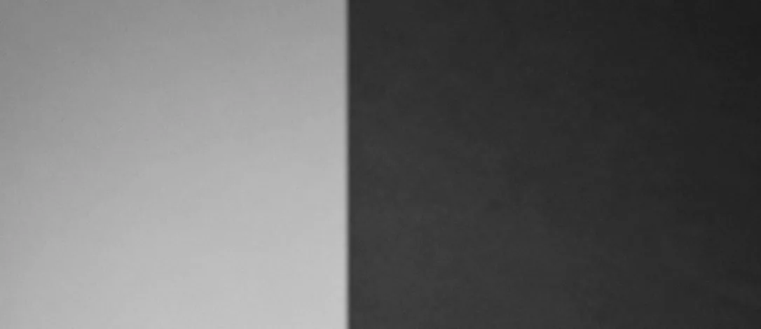 A plain wall divided by a hard diagonal of daylight, from the same photograph